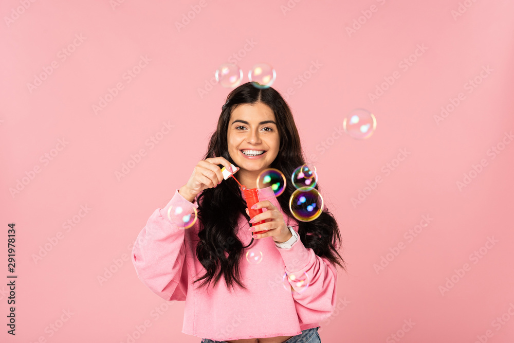 beautiful girl playing with soap bubbles isolated on pink beautiful girl playing with soap bubbles isolated on pink