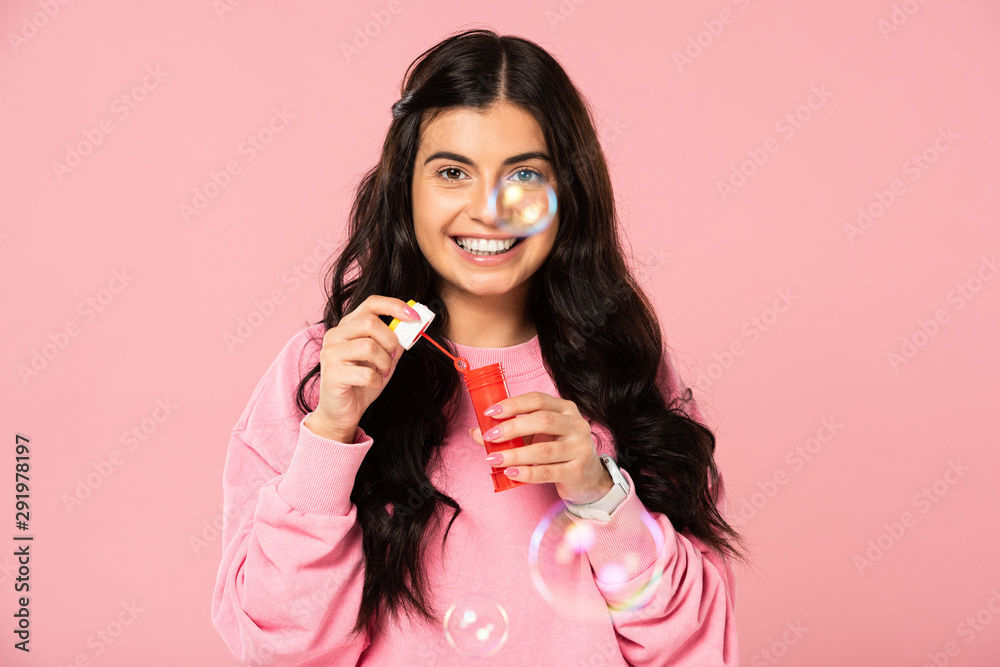 brunette young woman playing with soap bubbles isolated on pink brunette young woman playing with soap bubbles isolated on pink