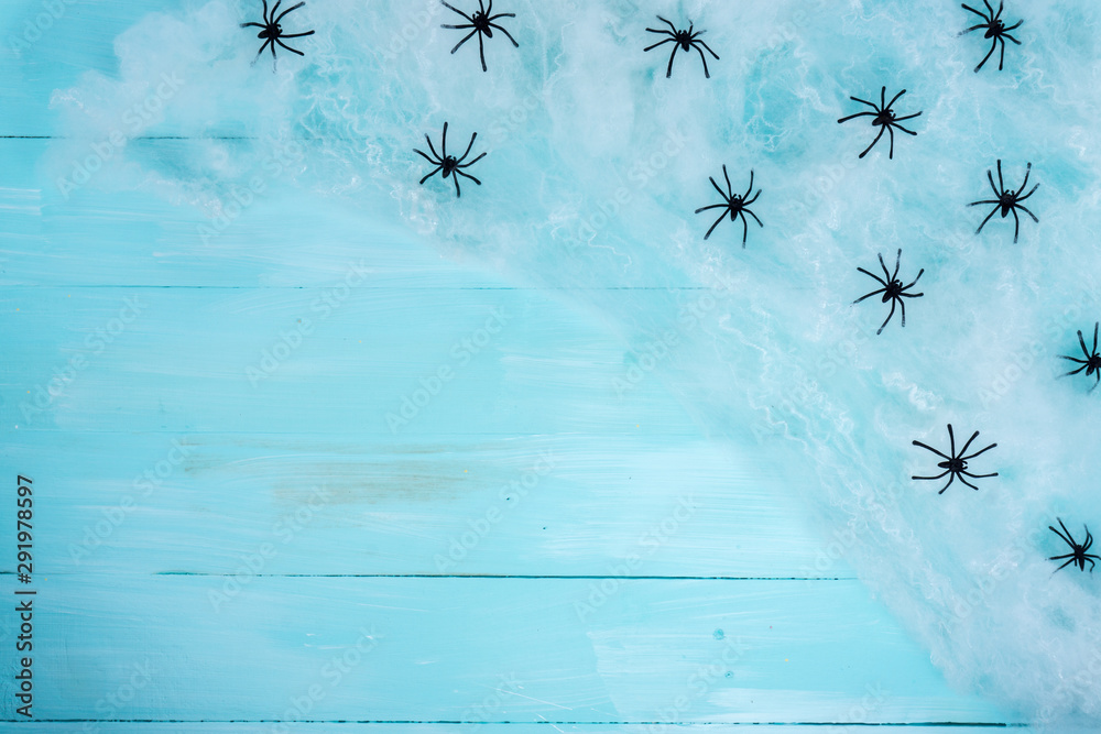 Halloween holiday background with spider and webs on blue wooden table with copy space for text. Flat lay, top view Halloween holiday background with spider and webs on blue wooden table with copy space for text. Flat lay, top view