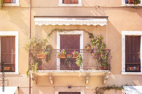 Mediterranean balcony with flowers. Building exterior in a italian location