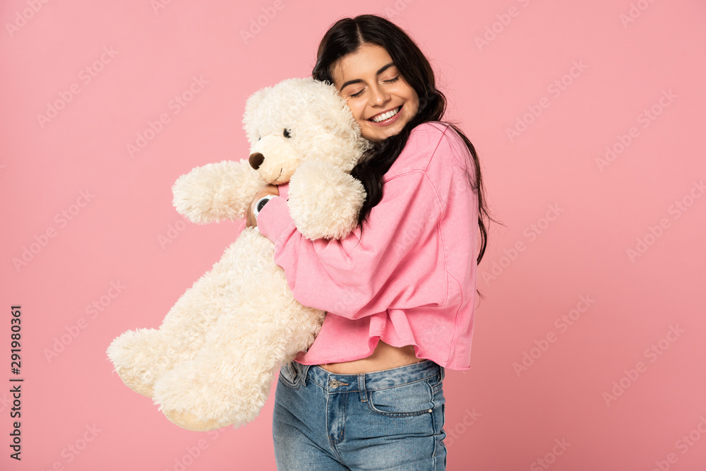 smiling young woman hugging teddy bear, Isolated On pink