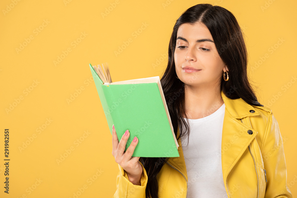 beautiful smiling student reading book, isolated on yellow beautiful smiling student reading book, isolated on yellow