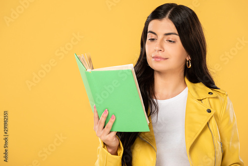 beautiful smiling student reading book, isolated on yellow