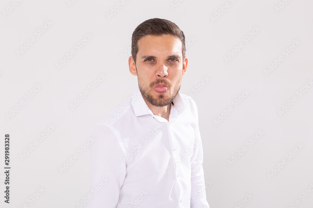 Handsome funny man with beard and moustache shows tongue on white background. Feeling and emotions. Handsome funny man with beard and moustache shows tongue on white background. Feeling and emotions.