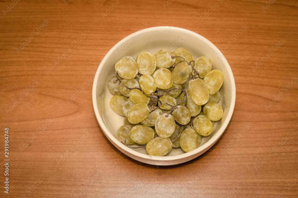 Grapes in a plate on wood Grapes in a plate on wood
