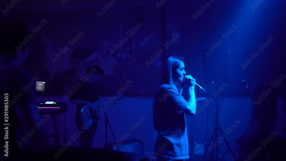 A guitarist rocking out while performing alongside an independent artist at a small concert A guitarist rocking out while performing alongside an independent artist at a small concert
