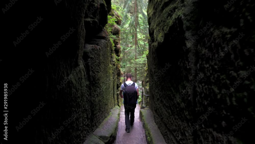 Male tourist goes through very narrow high ravine Male tourist goes through very narrow high ravine