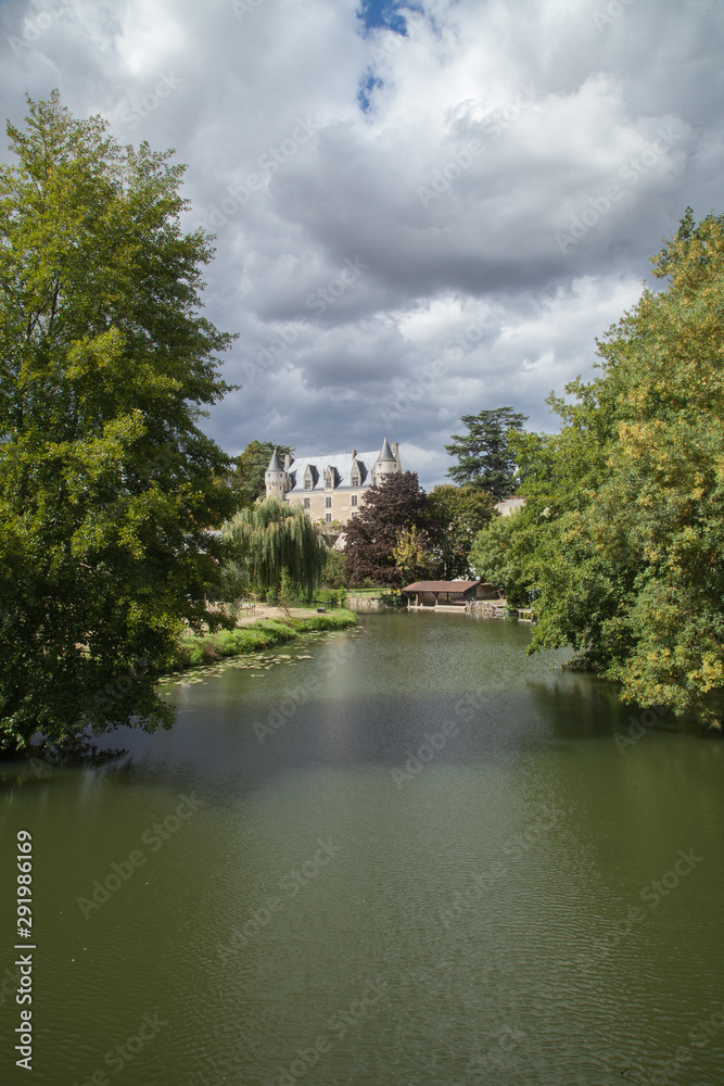 La rivière Indrois entre ses rives bordées d'arbres et le nouveau château de Montrésor