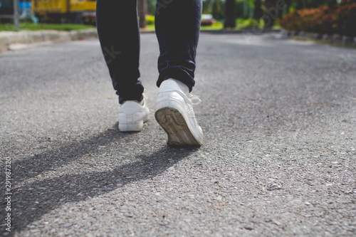 Step walk woman jeans and sneaker shoes walking on the road.