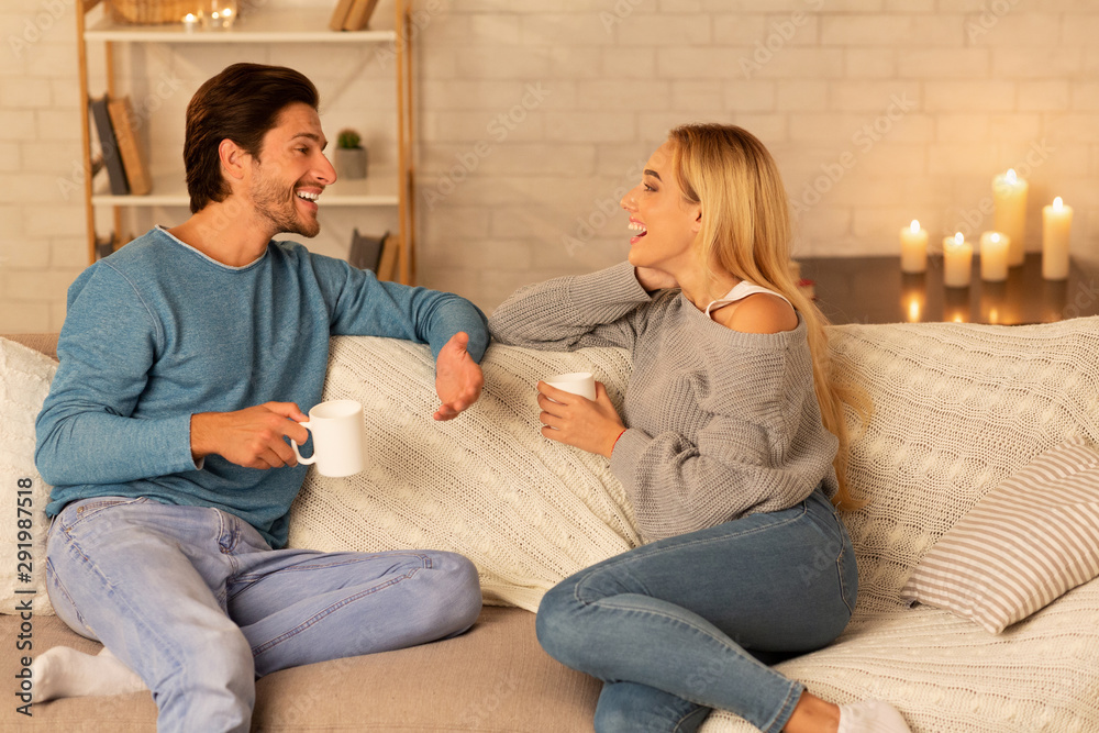 Happy Couple Spending Time Together Sitting On Sofa At Home