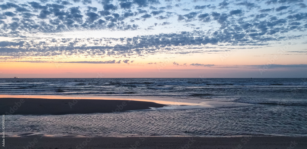 Obraz premium Beautiful panorama of sandbanks at North Sea coast during colorful sunset