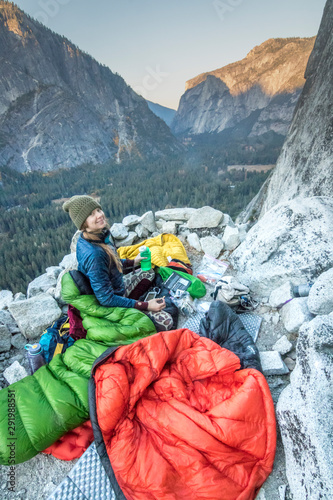 A young woman climber settles into her sleeping bag on Dinner Ledge photo