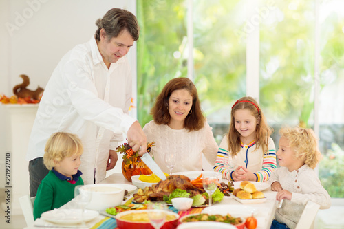 Family with kids at Thanksgiving dinner. Turkey.