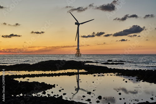 Sunset of western Jeju island with offshore wind turbine