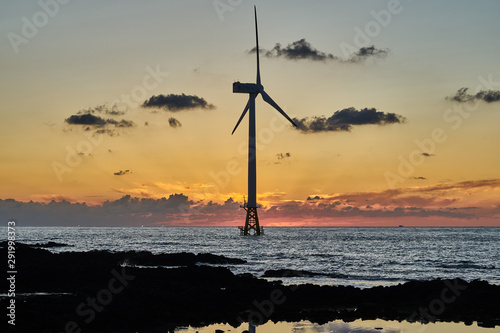 Sunset of western Jeju island with offshore wind turbine