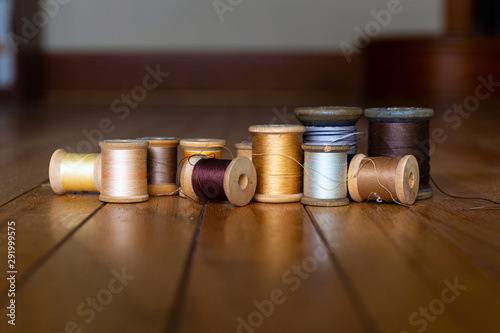 a group of antique wooden spools of thread on wooden background