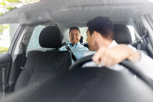 transportation, vehicle and people concept - middle aged male passenger talking to car driver photo