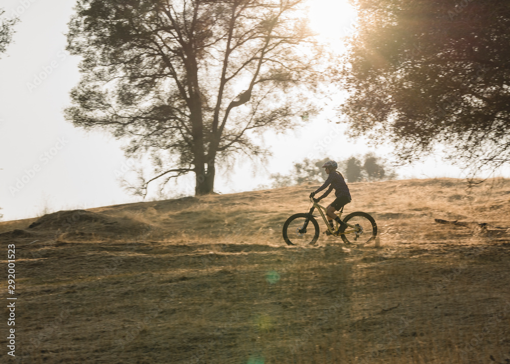 female mountain biker riding in the evening in fall female mountain biker riding in the evening in fall