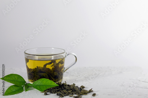 cup of green tea with leaves on the white background with copy space