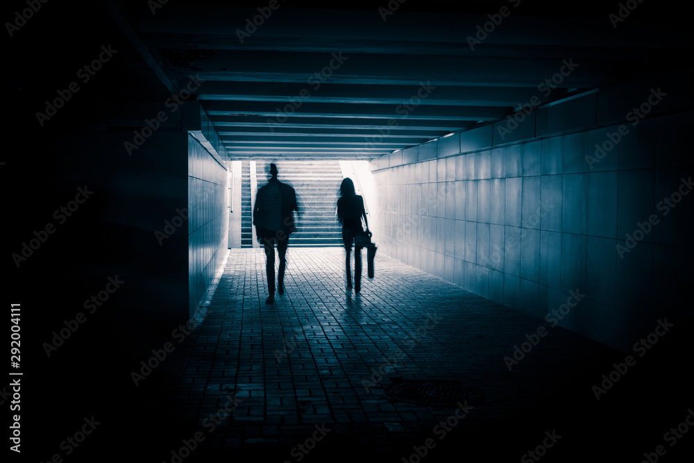 Young couple in the underground dark tunnel Young couple in the underground dark tunnel