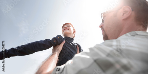 stylized photo.a happy father holds his son in his hands