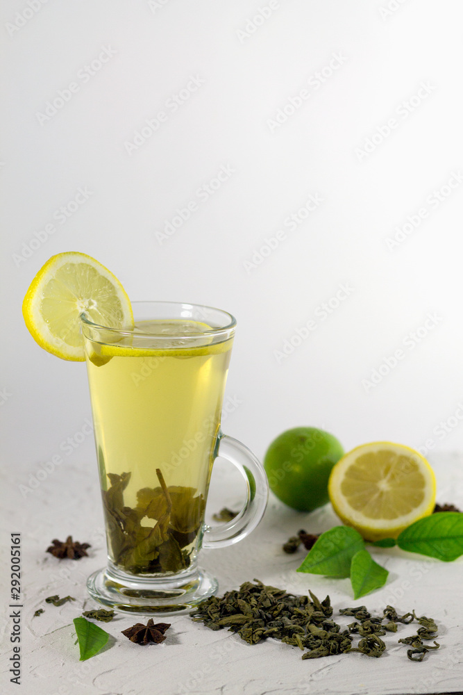 iced tea with lemon and green leaves on the white table iced tea with lemon and green leaves on the white table