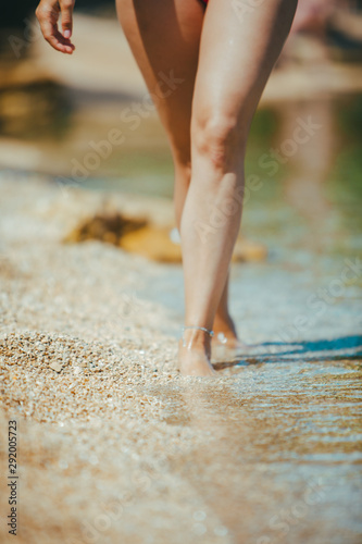 woman legs walking by seaside close up