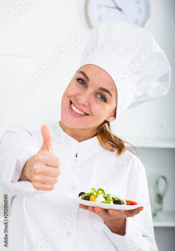 Girl cook shows plate of salad photo