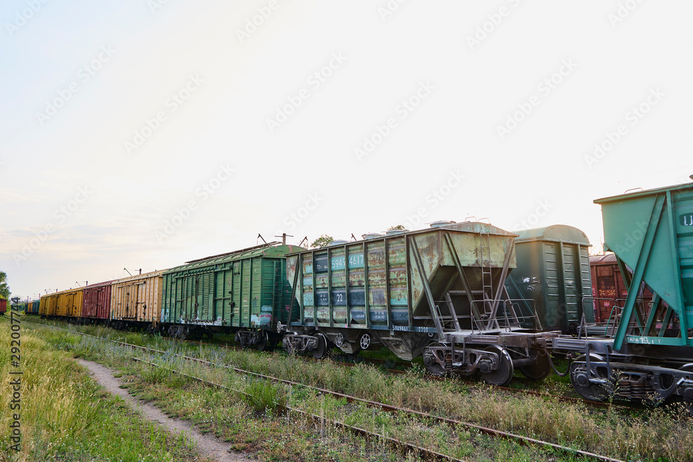 Colorful railway freight wagons in perspective at golden hours.
