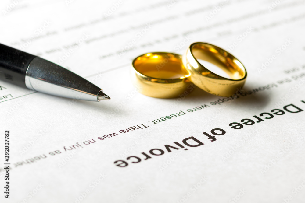 Divorce decree form with marriage ring and pen Divorce decree form with marriage ring and pen
