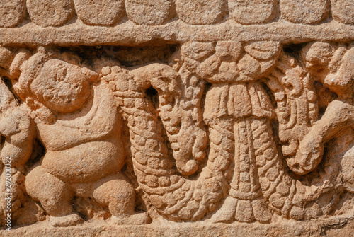 Patterns on stone relief of ansient Indian temple. Artwork on facade of sstone structure of South Indian, the 7th century