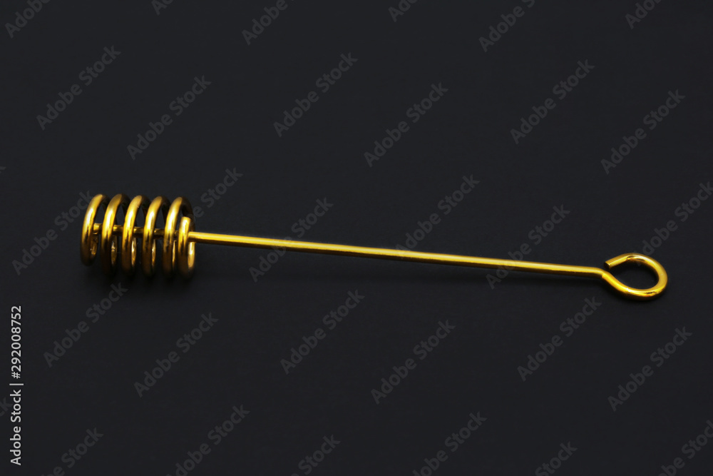 Elegant gold honey dipper on black background Elegant gold honey dipper on black background