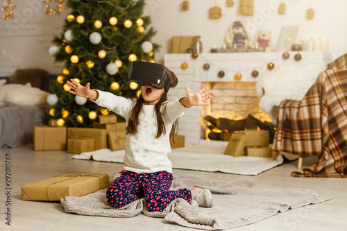 Obraz na plátně little girl in virtual 3D glasses at christmas at home