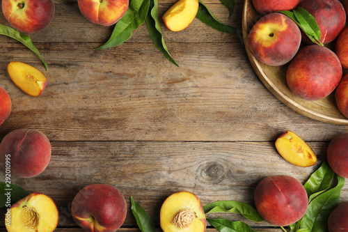 Flat lay composition with ripe peaches and space for text on wooden background