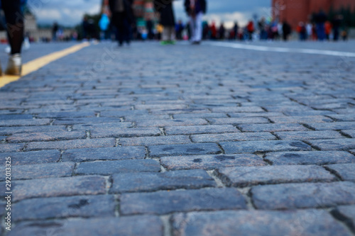 Stone pavement in perspective. Old street paved with stone blocks. Shallow depth of field. Vintage grunge texture.