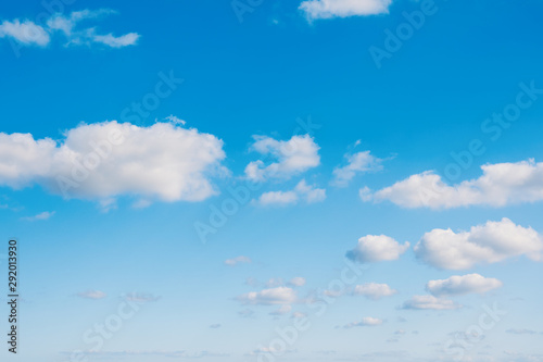 Blue sky background with cumulus clouds.
