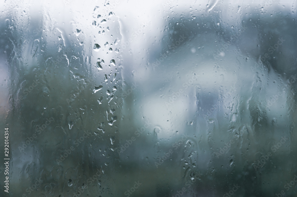 wet glass of window with raindrops, estate garden