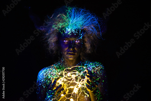 Fotografia Body art and contact lenses glowing in ultraviolet light