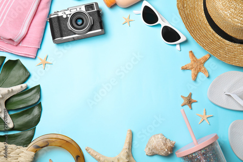 Flat lay composition with beach objects on light blue background. Space for text