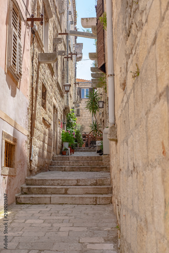 Narrow old stone street with stone houses and facades in historic fortified Korcula town, Korcula Island, Dalmatia, Croatia