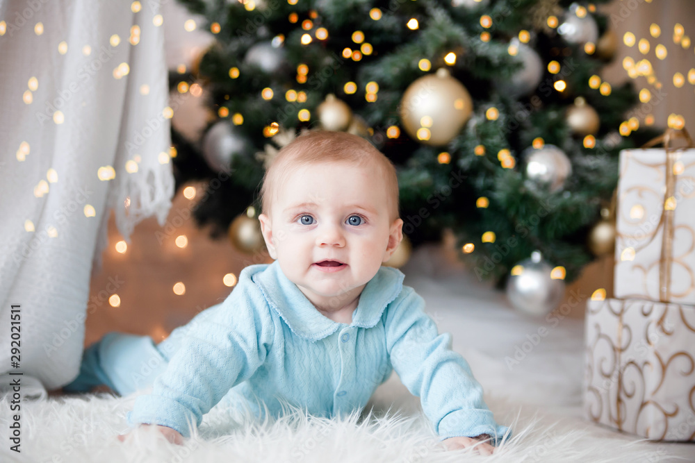 Cute baby on floor at Christmas tree Cute baby on floor at Christmas tree
