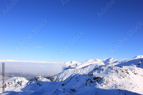 skyline with snow-covered mountains under blue sky © Luciernaga