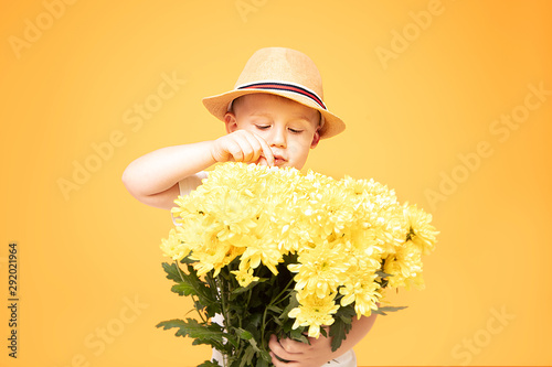 Happy kid in summer hat and flowers.