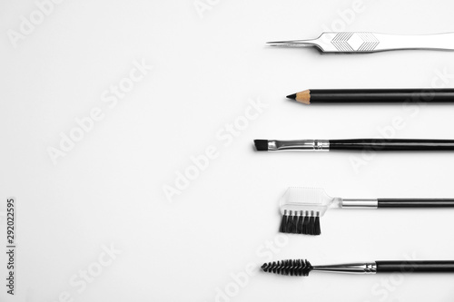 Set of professional eyebrow tools on white background, flat lay. Space for text