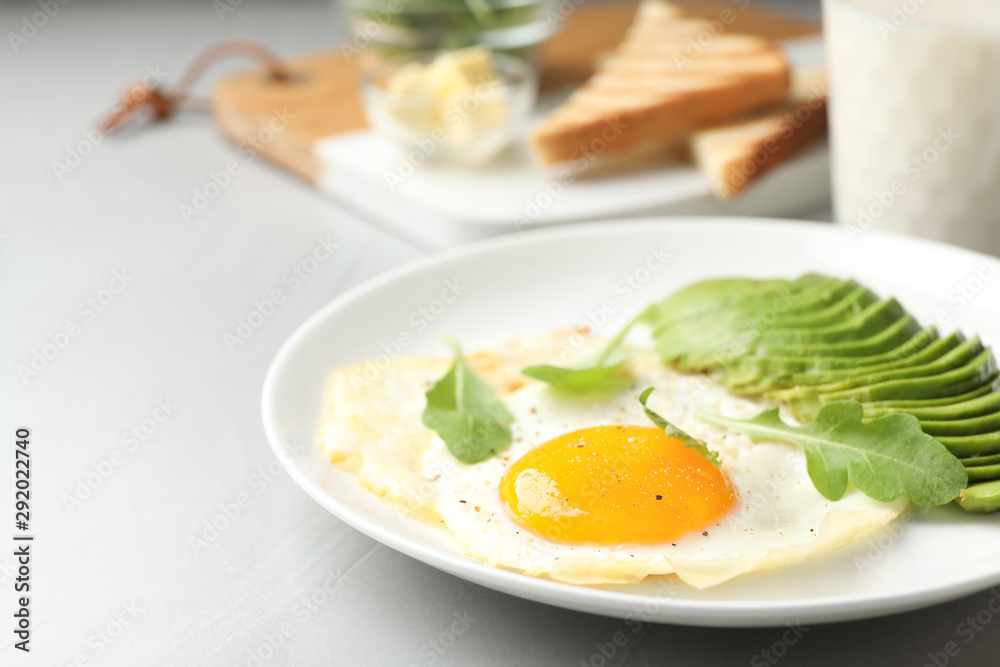Tasty breakfast with fried egg and avocado on table, closeup Tasty breakfast with fried egg and avocado on table, closeup