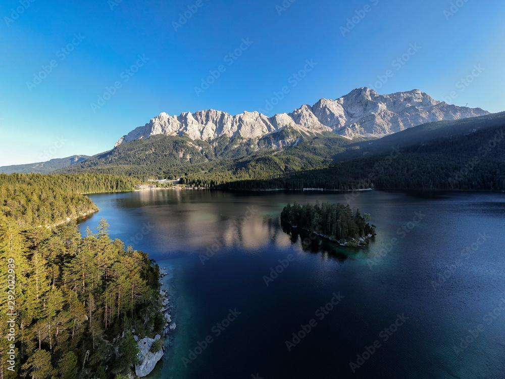 Aerial panoramic image of the Eibsee lake and Zugspitze mountain with blue sky