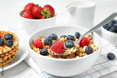 Tasty breakfast with muesli on white wooden table, closeup