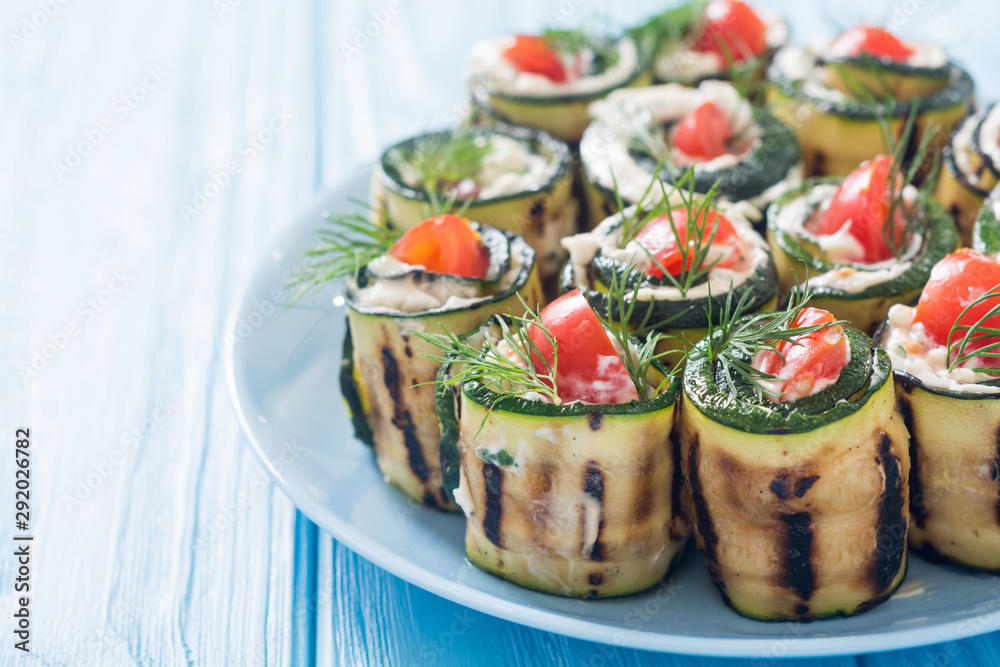 Zucchini rolls with cream cheese , tomatoes and dill