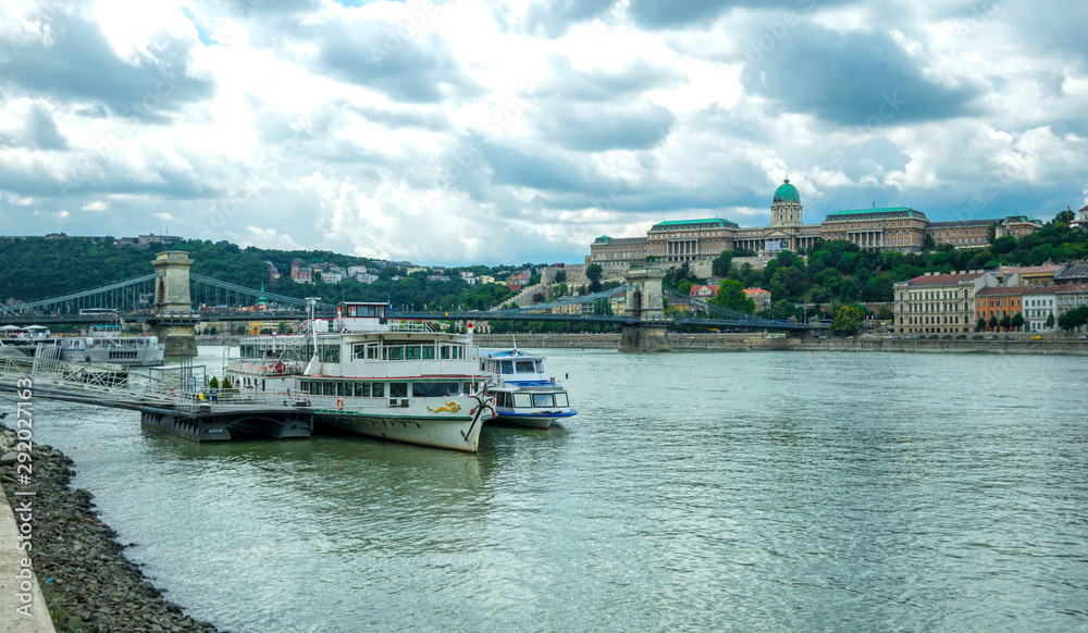 Ancient buildings on the Danube embankment in Budapest and tourist pleasure boat