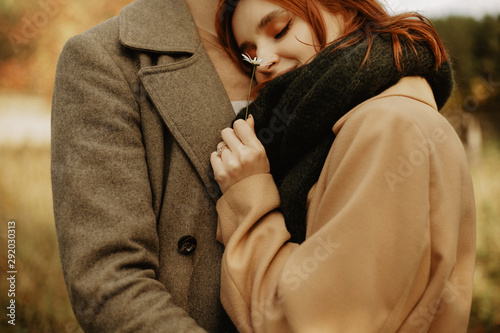 Принти на полотні beautiful girl in a brown coat is dressing a guy